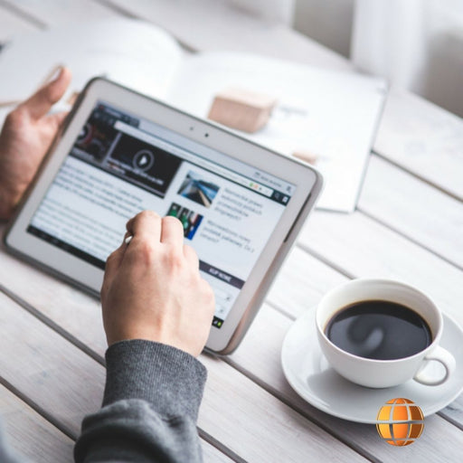 Una persona tomando Café, mientras esta con su tablet  viendo una website. 